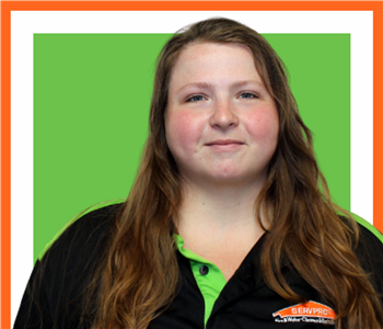 female employee with long hair under SERVPRO sign