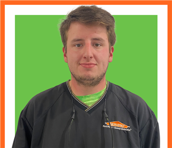 Tristen, SERVPRO employee in front of a green sign, male