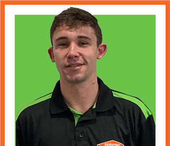 Kyle Workman, male, SERVPRO employee in front of green sign, white background