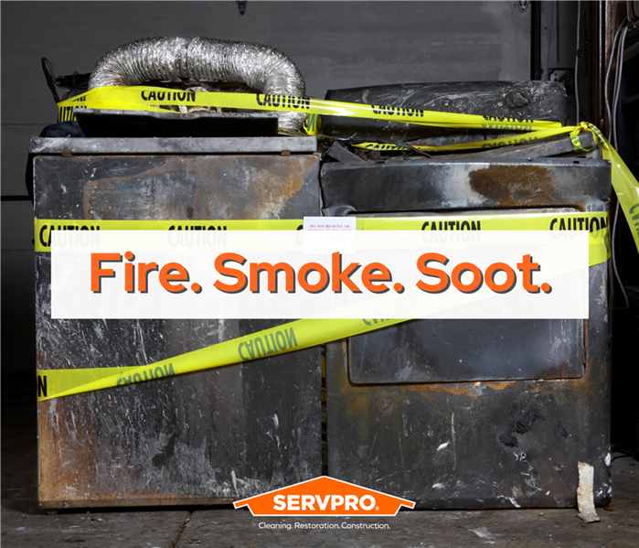 dryers covered in soot and caution tape, white text box with orange letters "soot fire smoke" SERVPRO logo bottom center