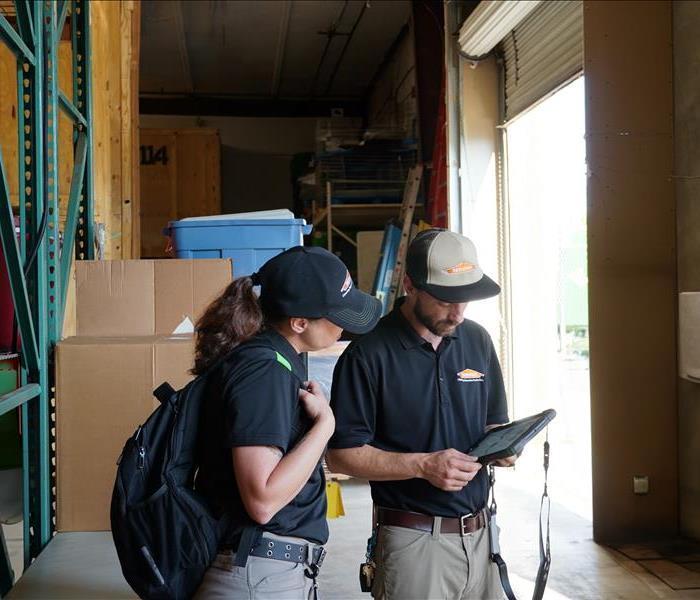 two SERVPRO technicians working with an ipad